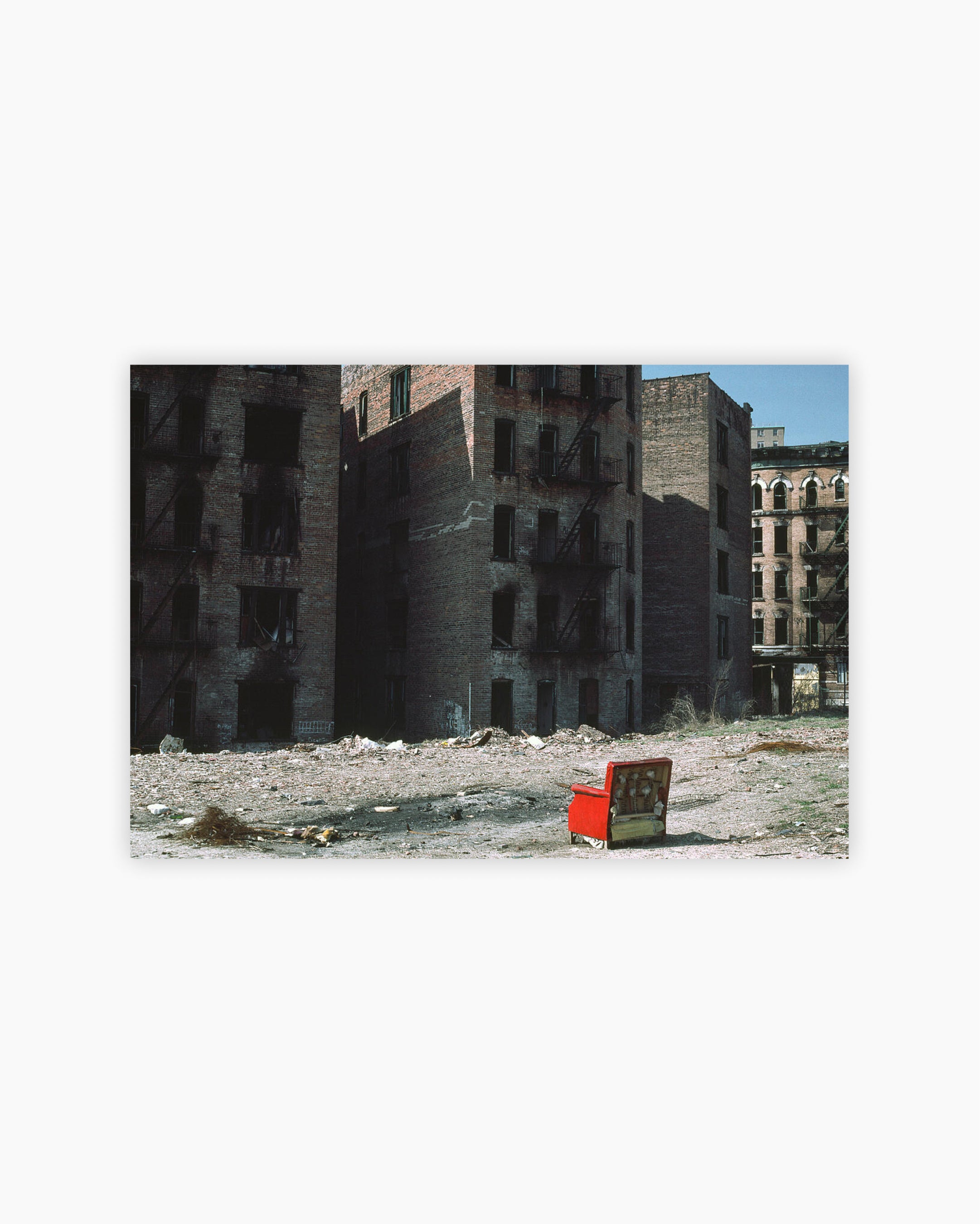 Red chair in front of burned out apartment buildings. Bronx, New York City, USA, 1983