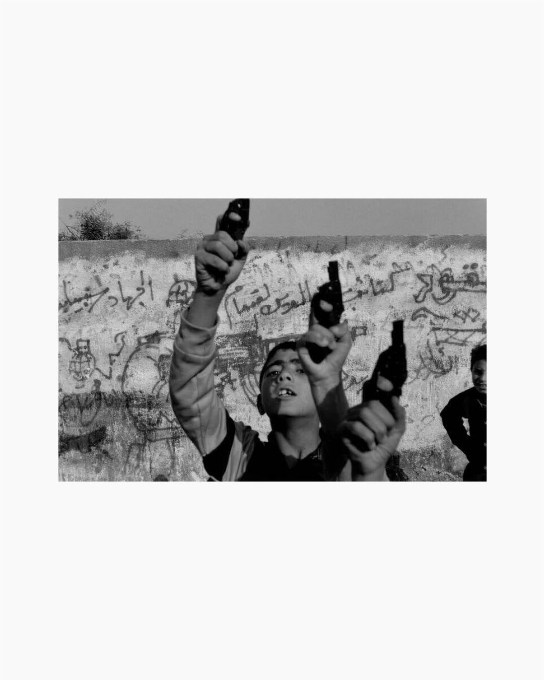 Fine Print: Children holding toy guns in the air. Palestine, 1993